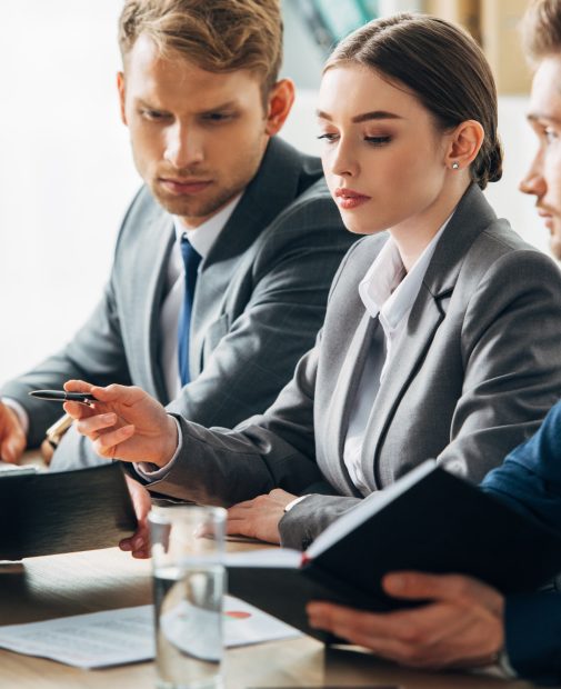 Selective-focus-of-recruiters-looking-at-employee-showing-clipboard-during-job-interview. Jpg